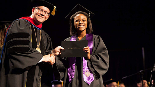 Daniela Iheanacho receiving her diploma from SAGU President, Dr. Kermit Bridges,  during the 2014 Commencement Ceremony